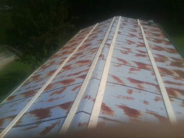 Rusted metal roof panels with new wood purlins before replacement — Storm Damage Roof Repair in Rosanky by Roofing Brothers