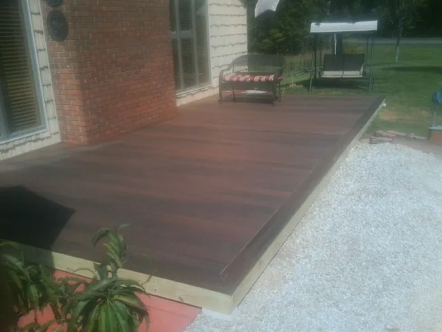 Freshly stained wood deck built against a brick home in Rosanky