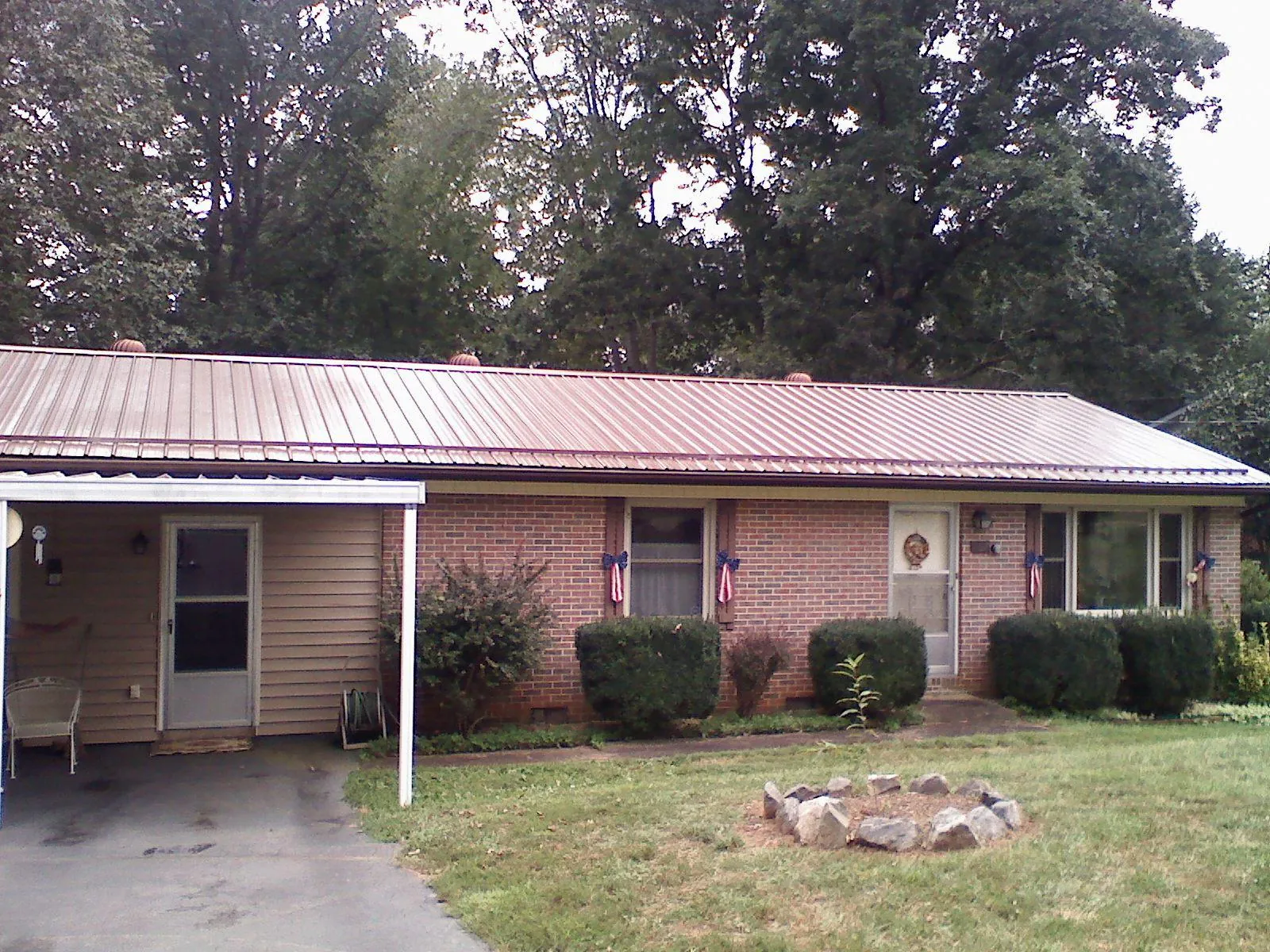 Bronze metal roof and carport on a brick ranch home — Roof Repair work by our crew in Rosanky