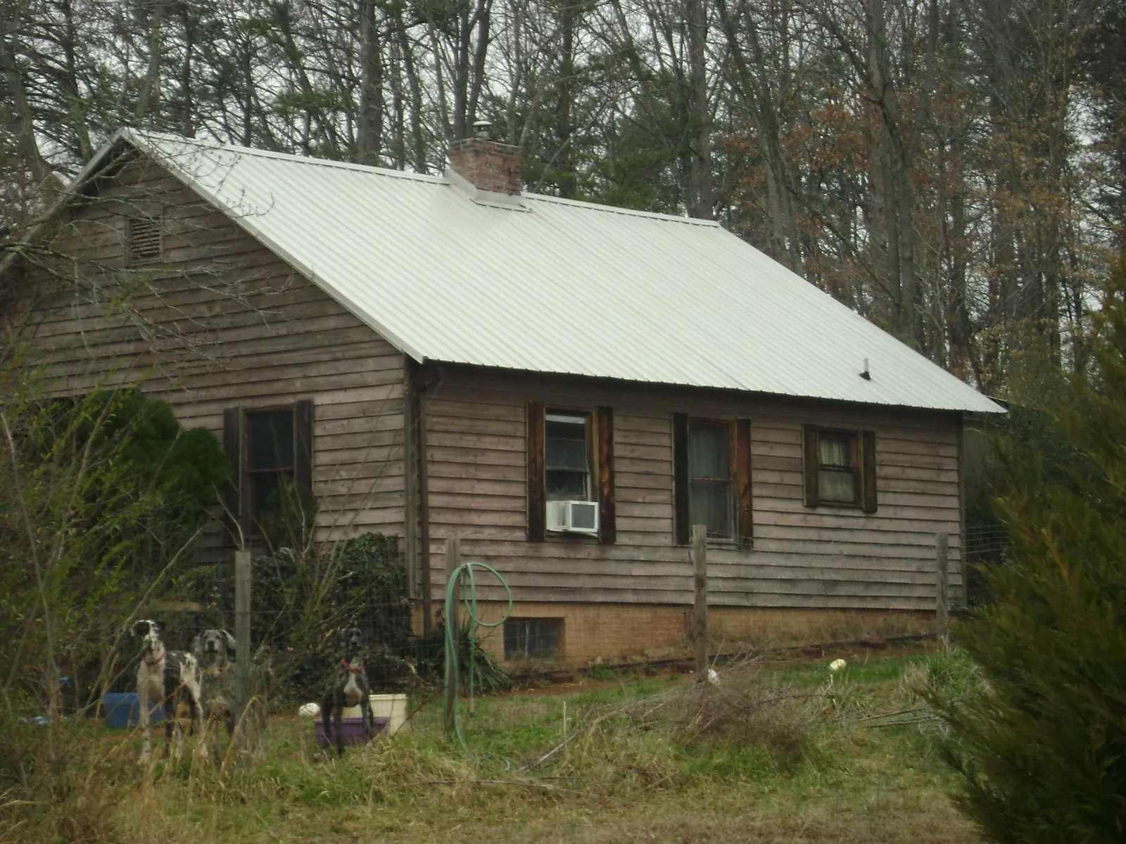 White metal roof on an old wood sided farmhouse, from a Metal Roof Installation job in Rosanky